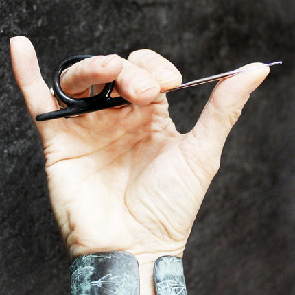 Dreadlock crochet hook with black ring handle on white background
