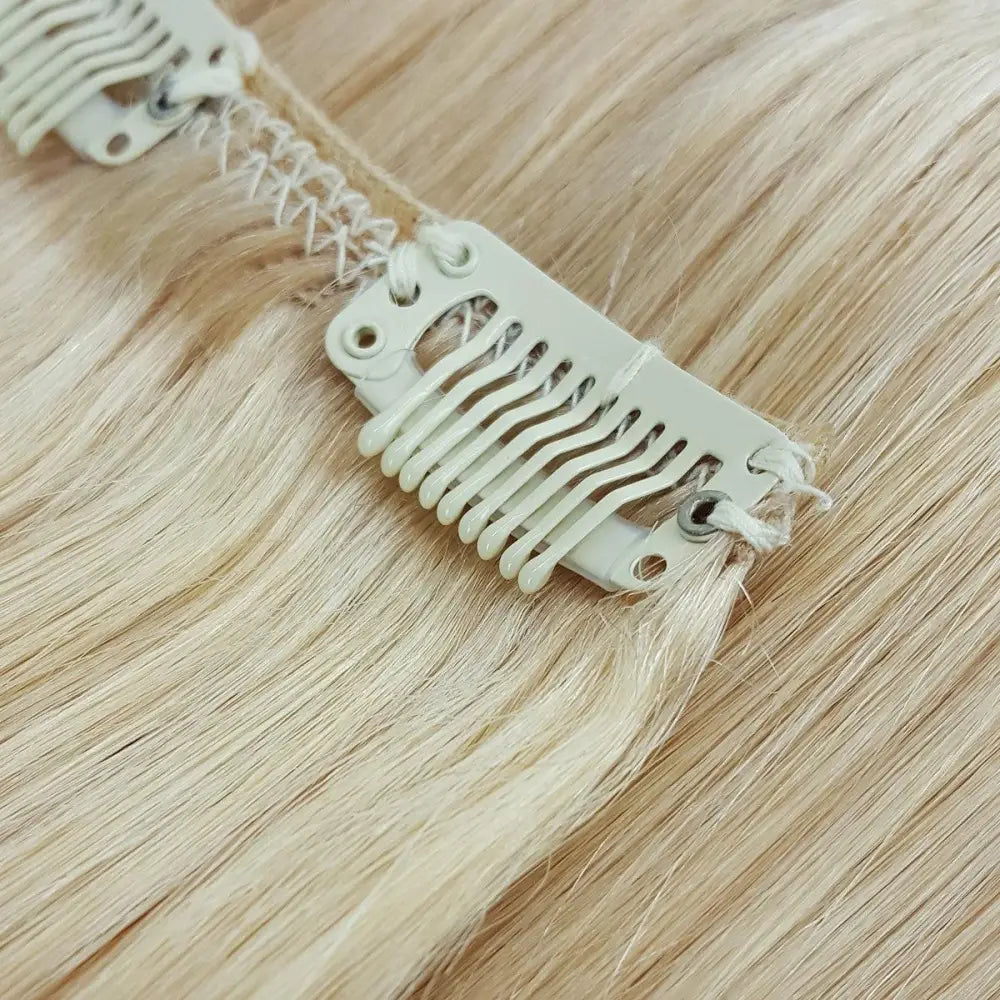 Close up of snap clip on human hair clip-in extensions in platinum blonde 613