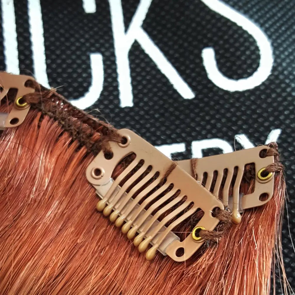 Close up of auburn snap clip on dark natural red human hair 7 piece clipset extensions