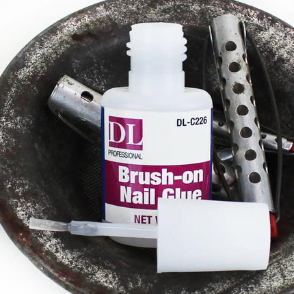 Brush on adhesive with screw top brush shown in dish with vintage hair curlers