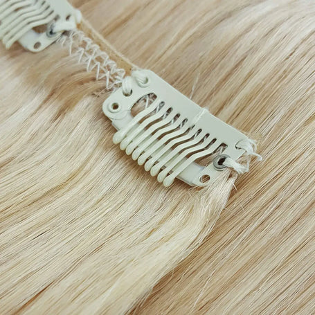 click here for clip in hair - image is a close up of a clip in hair extension with platinum blonde hair