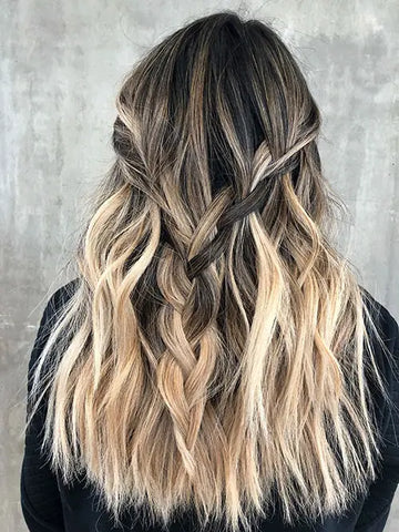back of woman's head with multidimensional dirty blonde hair extensions styled with soft braids