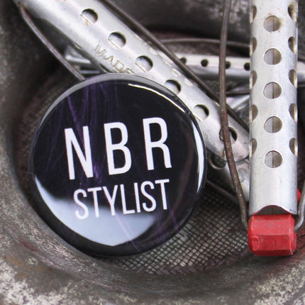 Close up of NBR Stylist button, with vintage hair rollers