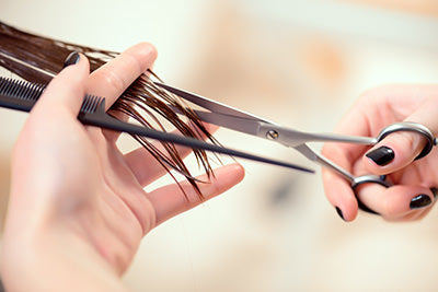 trimming split ends from hair with scissors