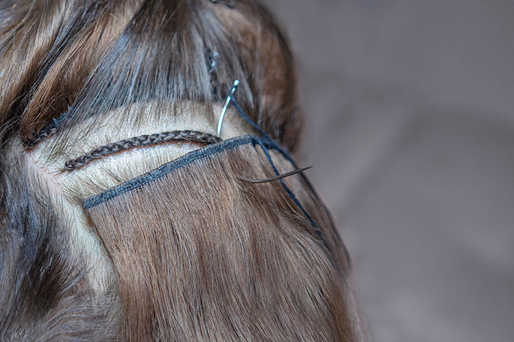 weaving needle being used to install hand tied wefted hair extensions